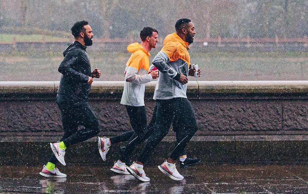 Trois hommes qui courent sous la pluie