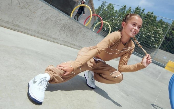 jeune fille en survêtement beige qui prends la pose