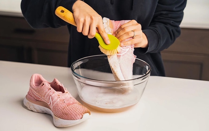 nettoyage à la brosse d'une paire de basket de sport rose