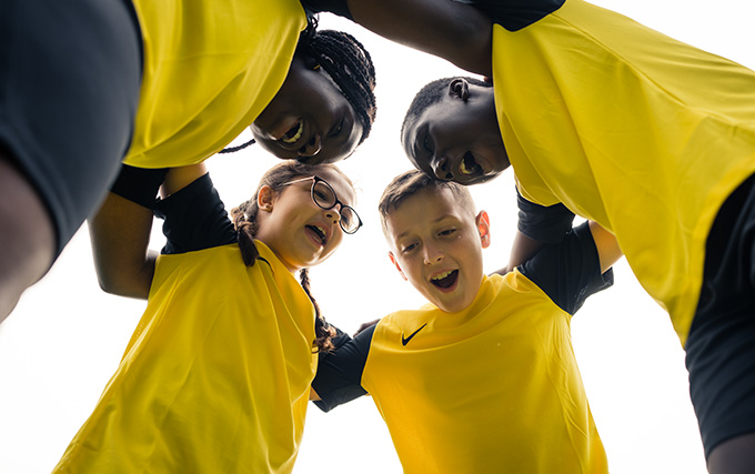 Enfants dans des tenues Nike jaune qui font un cri de guerre 