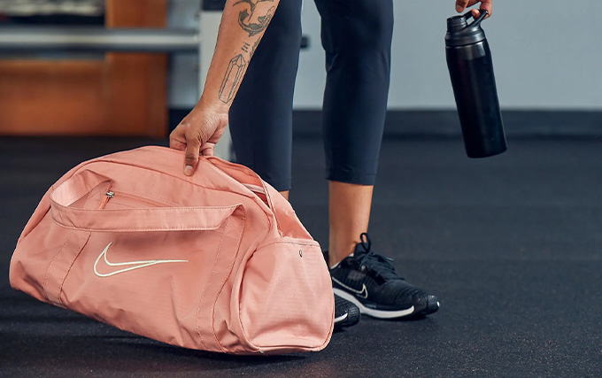 Femme qui sort une gourde de son sac pour s'hydrater