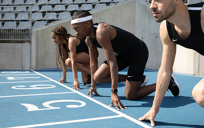 Trois athlètes sur une piste dans des starting-blocks