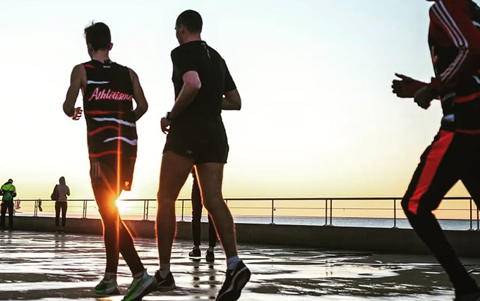 trois athlètes bien équipés pour courir au coucher de soleil